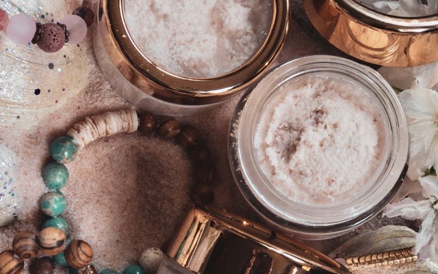 Bols de gommage aux sels et sucres naturels posés sur un plateau